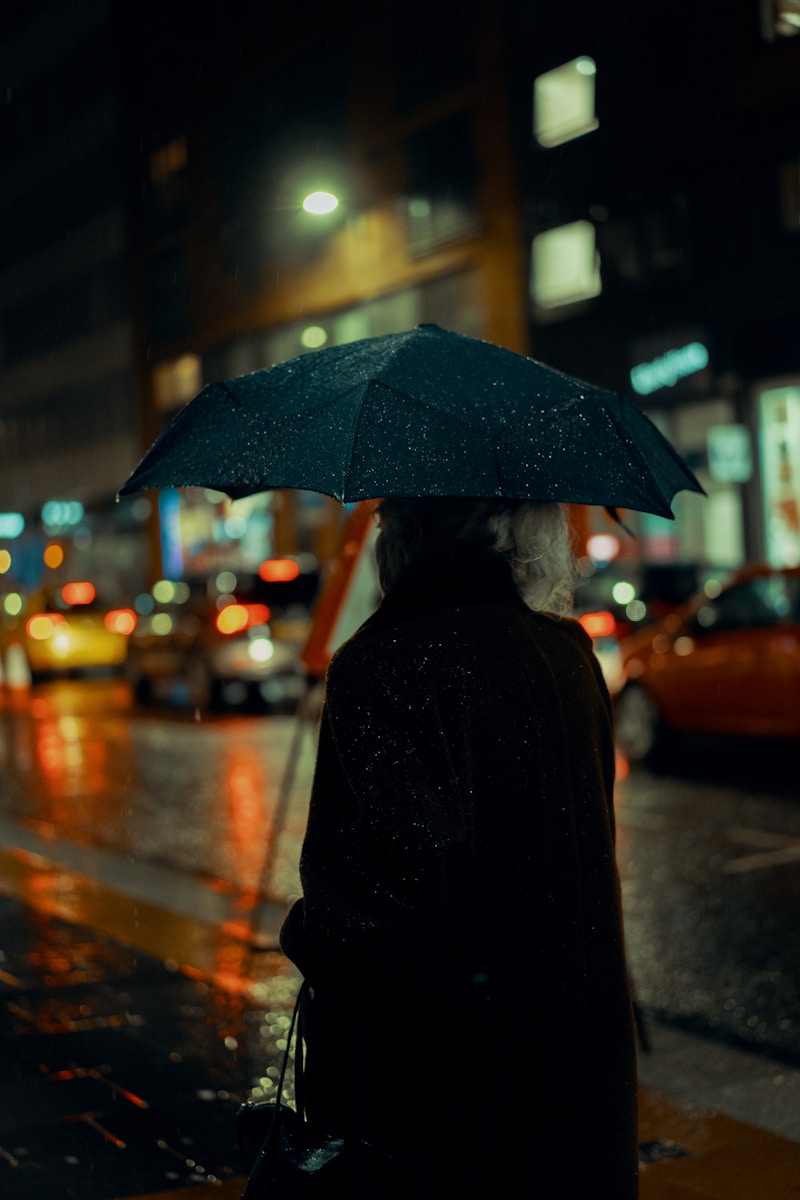 person in black coat holding umbrella symbolizing water damage